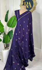 Purple saree with gold patterns on a mannequin against a white wall with 'RA' logo.