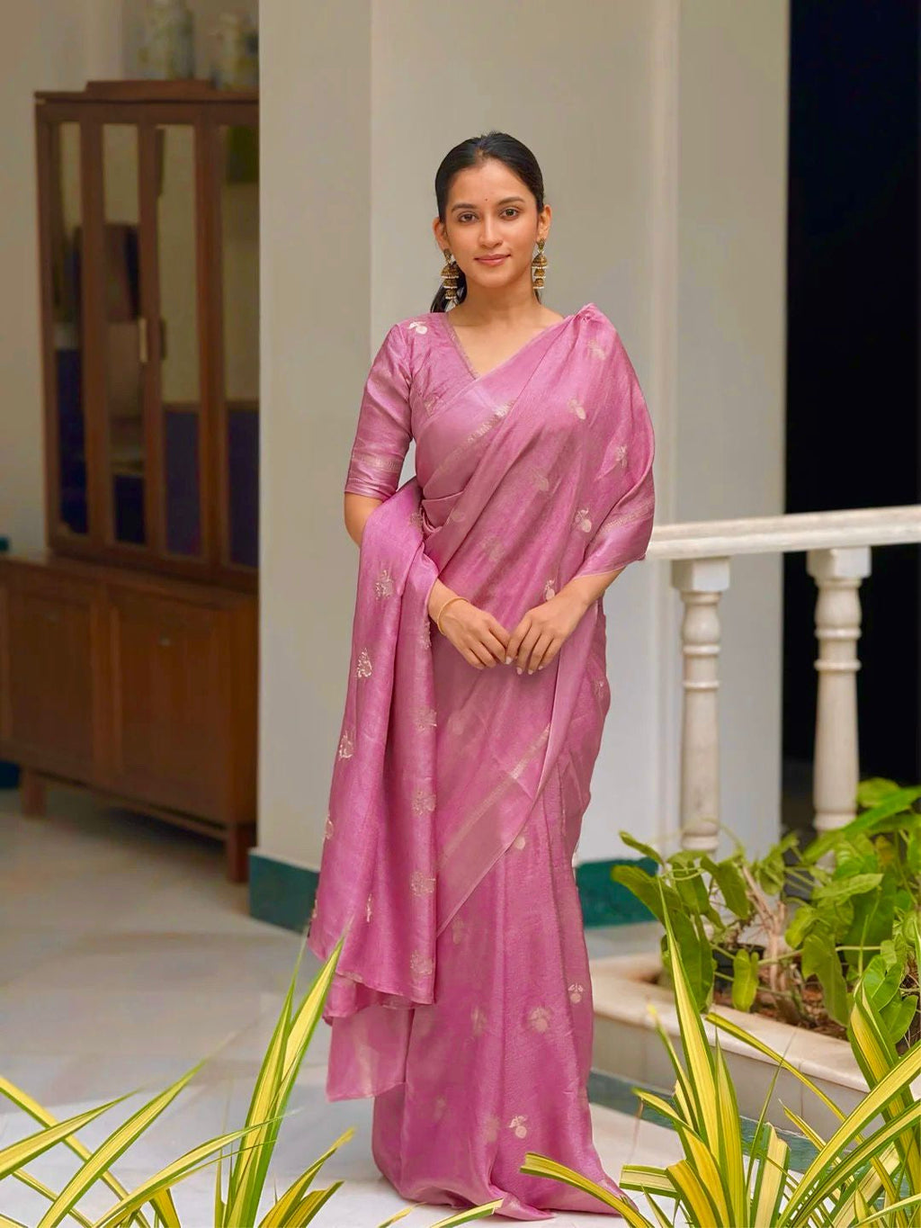 Woman wearing a pink saree with a white background