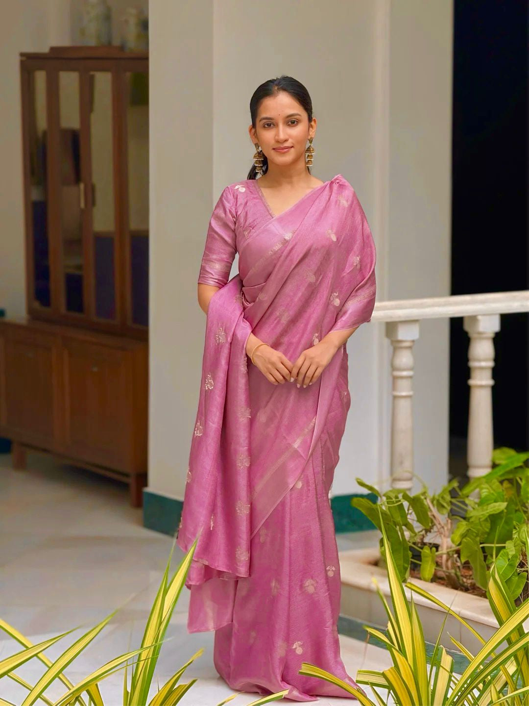 Woman wearing a pink saree with a white background
